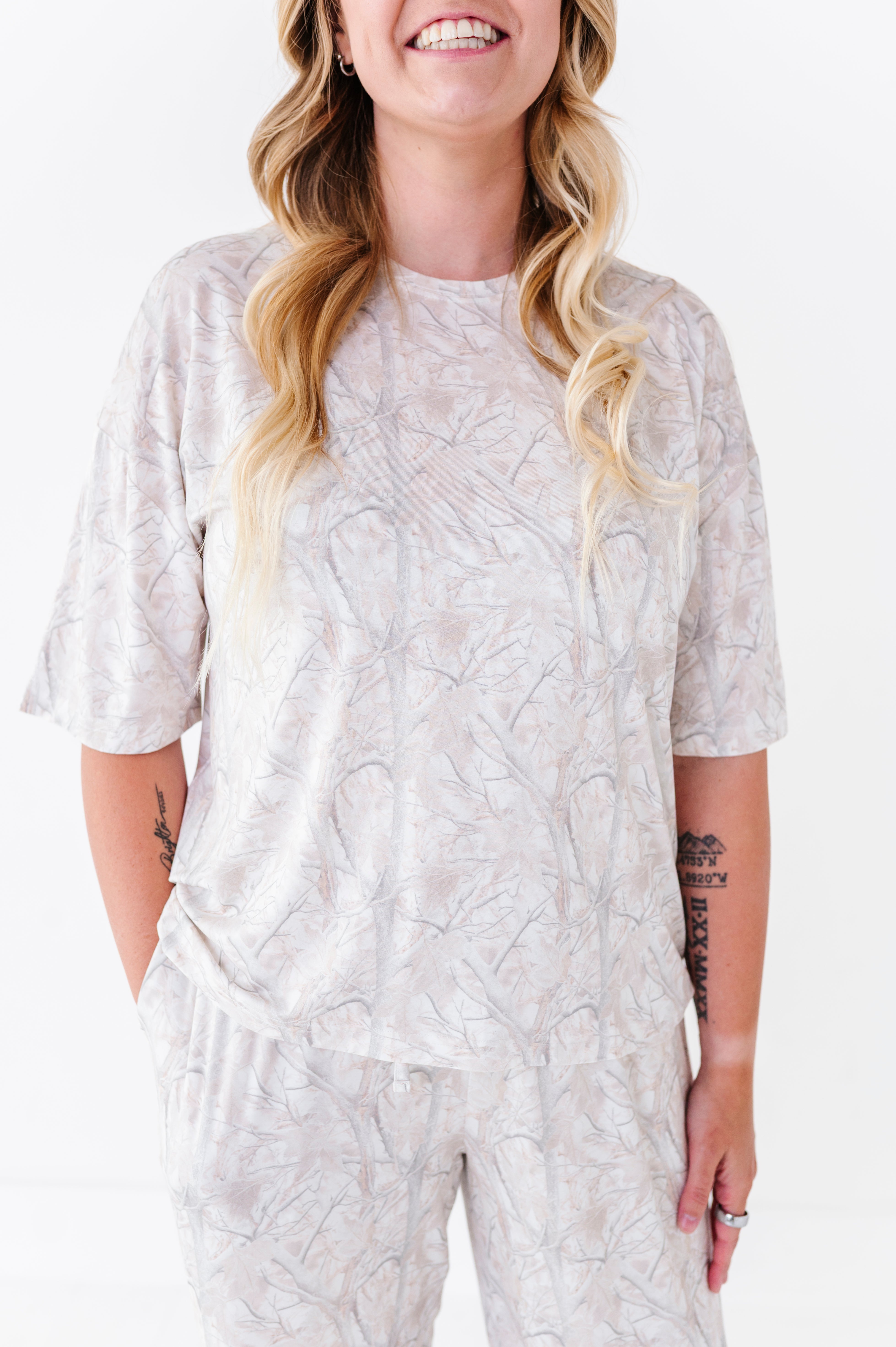 Woman wearing a light-colored patterned outfit on a white background